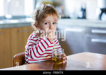 2 year-old boy drinking fruit juice. Stock Photo