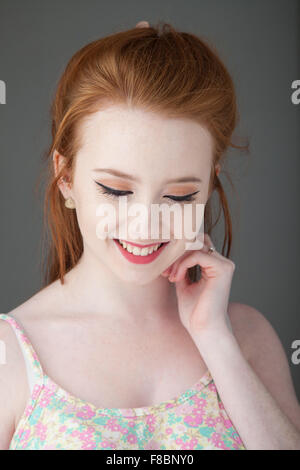 Portrait of a redheaded young woman looking demure. Stock Photo