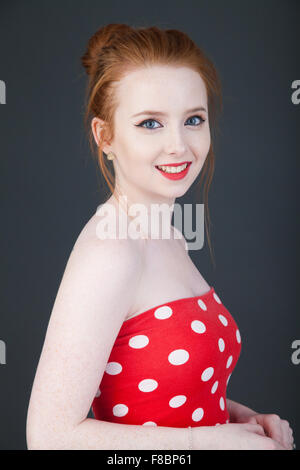 Portrait of a red headed young woman wearing a polka dot top. Stock Photo