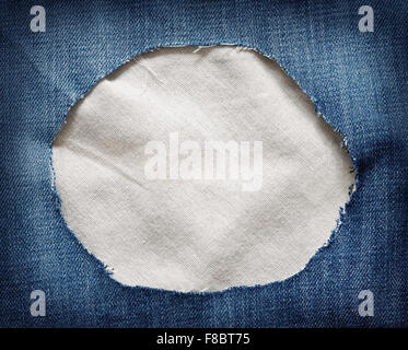 White fabric texture with torn blue jeans Stock Photo