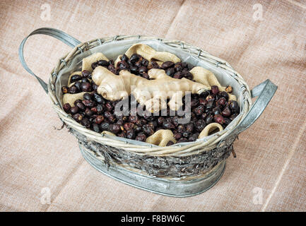 Dried rosehips and ginger arranged in the wicker tin basket. Healthy lifestyle. Stock Photo