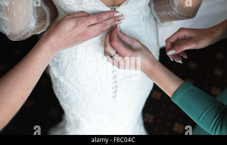 Bride putting on her dress Stock Photo