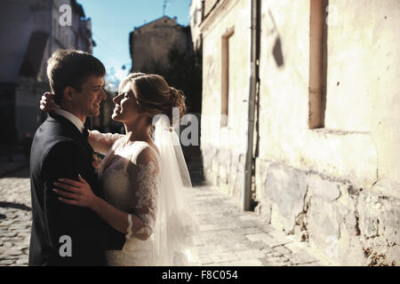 bride and groom posing on the streets Stock Photo