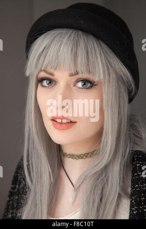 An eighteen year old girl with dyed gray hair snarling towards the