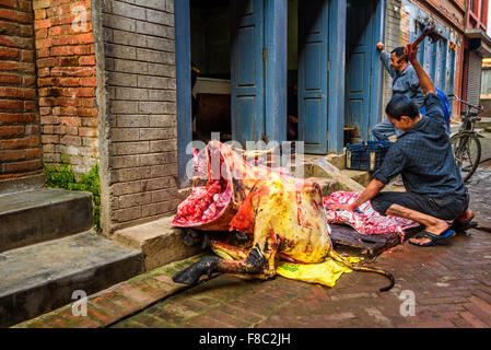 Nepalese butcher carves a cow in the street of Kathmandu Stock Photo