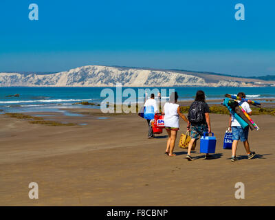 People on the beach at Compton Bay on the Isle of Wight England UK looking north west towards the chalk cliffs at Tennyson Down Stock Photo