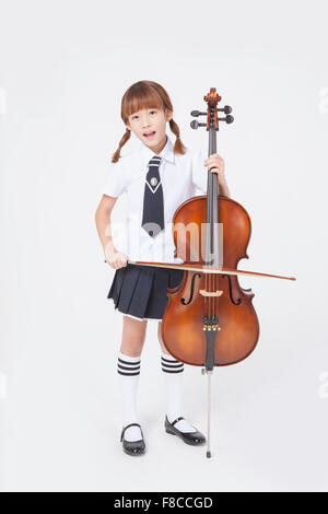 Girl in a school uniform playing a violin isolated on white background ...