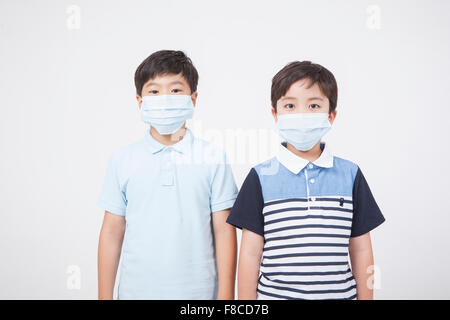 Two elementary school boys wearing mask each and staring forward Stock Photo