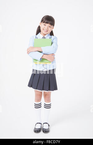 School girl holding book standing at school Stock Photo - Alamy