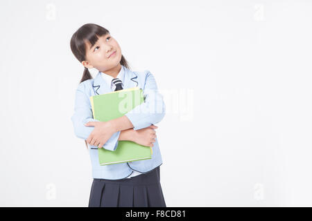 Girl in school uniforms holding three books Stock Photo - Alamy