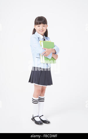 School Girl holding books standing at school Stock Photo - Alamy