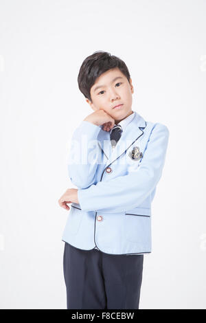 a boy in school uniform putting money in his piggy bank Stock Photo - Alamy
