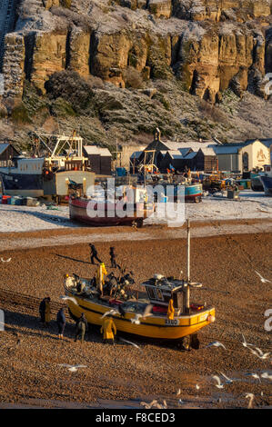 Fishermen hauling a boat from the sea, The Stade. Hastings old town. East Sussex. England. UK Stock Photo