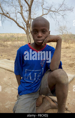 Young African boy looking at the camera with a arid landscape Stock Photo