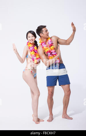 Couple in beach wear and a flower necklace each dancing together Stock Photo