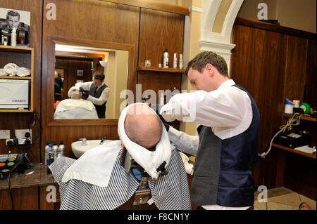 Man receiving hot towel shave from barber in Londonderry, Northern Ireland. Stock Photo
