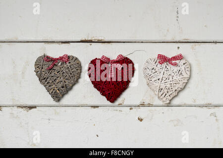 Valentine's day. Vintage style. Three hearts on old white wooden background. Stock Photo