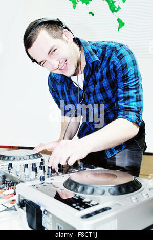young dj man with headphones and compact disc dj equipment on party Stock Photo