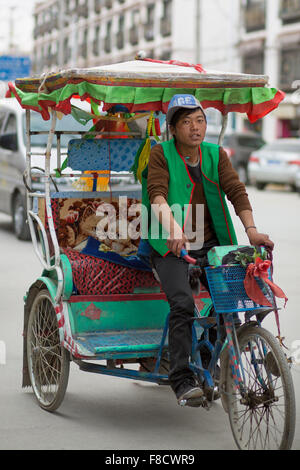 Man riding his rickshaw in the old city of Lhasa Stock Photo