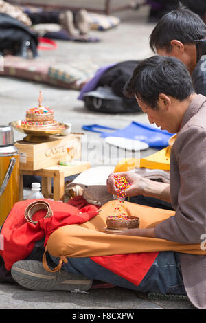 Group of men praying in front of a temple in Lhasa Stock Photo