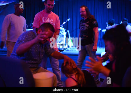 Oct. 21, 2015 - Wilmington-Cincinati-Hamilton, Ohio, US - Pastor Juan Hernandez holds a bucket for Chasity Holt, a heroin addict who has just thrown up following an emotional group prayer to ''cast out Satan'' from her body during a worship service at City on a Hill church in Cincinnati, Ohio. Lead pastor Billy Price, at right, has devoted the ministry to helping the most desperate heroin addicts such as Holt, who showed up saying she had overdosed only the night before. © Miguel Juarez Lugo/ZUMA Wire/Alamy Live News Stock Photo