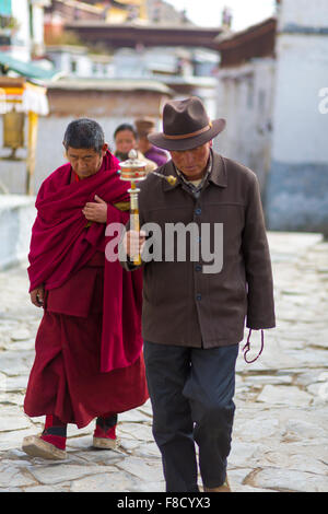 Two praying monks passing in the street Stock Photo