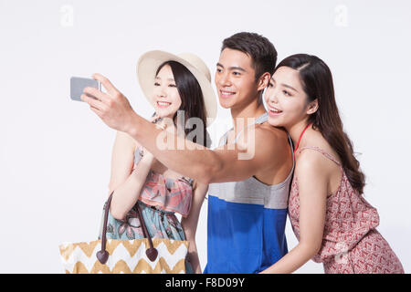 Man in sleeveless shirt taking a self picture with two women in tourist style Stock Photo