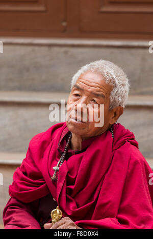 Old monk praying in Kathmandu Stock Photo