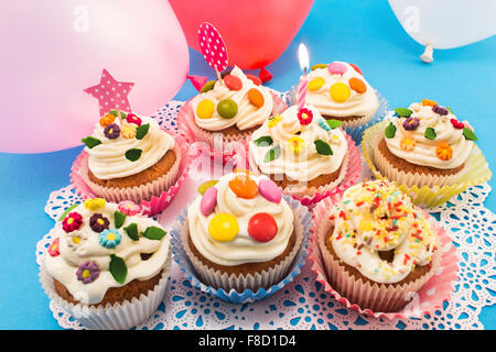 Birthday cupcakes with balloons on a blue background. Stock Photo