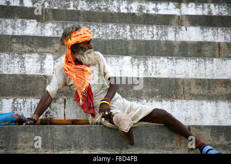 Legged old Sadhu standing up on the stairs of a ghat in Varanasi Stock Photo