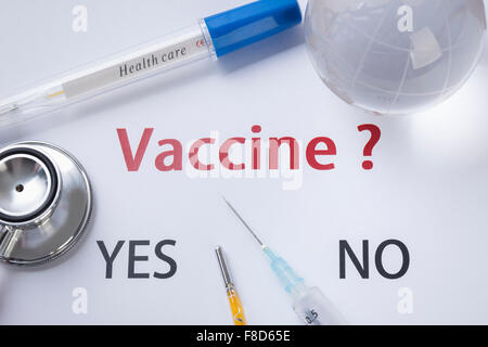 High angle of word Vaccine with a question mark and words for the answer YES and NO written on white background with other Stock Photo