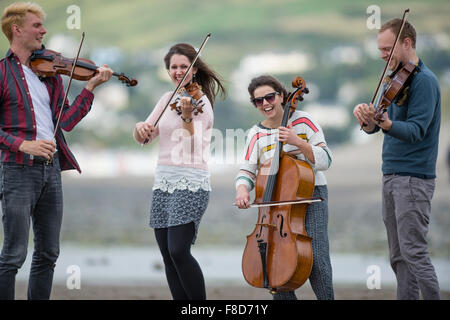 Young classical musicians: The Solem String Quartet playing outdoors on the beach  at Aberystwyth Music Fest 2015 Stock Photo