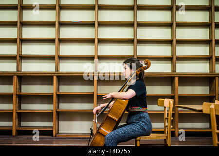 Young classical musicians: The cellist of the The Solem String Quartet playing solo on her cello in an empty library at Aberystwyth Music Fest 2015 Stock Photo