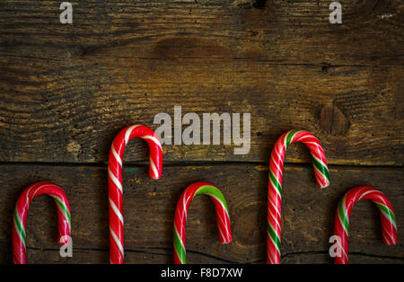 Candy canes on wooden boards - holidays background Stock Photo