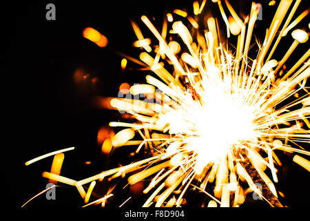 Bright Christmas sparkler closeup on a black background soft focus