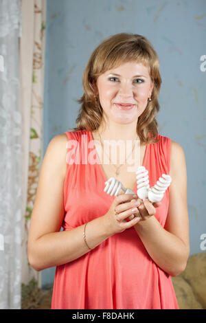 Girl holding energy saving compact flourescent light bulbs Stock Photo