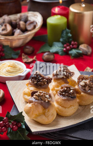 Bigne alla crema di castagne con fichi e noci su sfondo natalizio Stock Photo