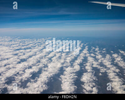 View of field of clouds in a row through window of an aircraft on flight from Bangalore to Dubai. Stock Photo