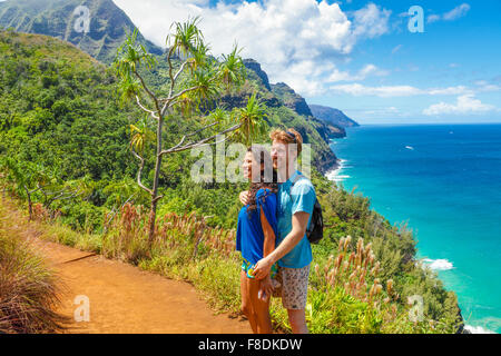 Young couple enjoys views along the Kalalau Trail on Kauai Stock Photo