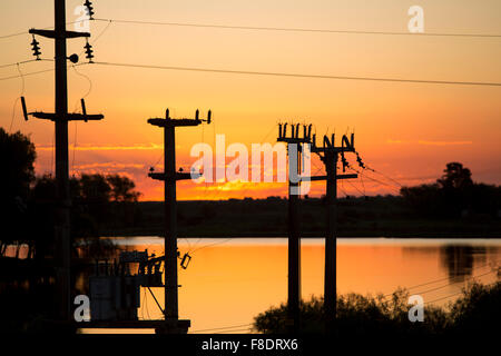 Sunset on Rio de la Plata with electrical wires, Argentina Stock Photo