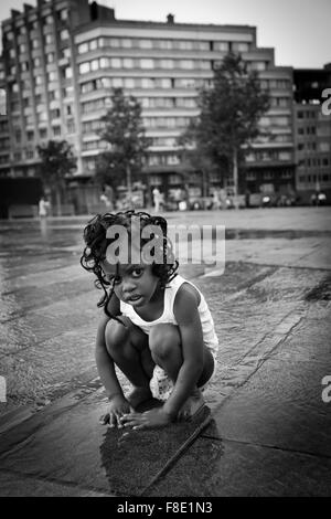 Black young girl on the Square of Flagey after the rain in a hot day in Brussels Stock Photo