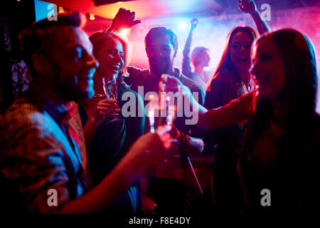 Group of young people celebrating with drinks in nightclub Stock Photo