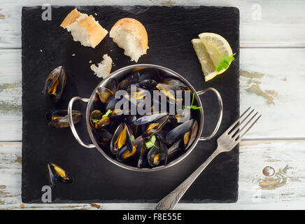 Boiled mussels in a dish on a dark background. Top view Stock Photo