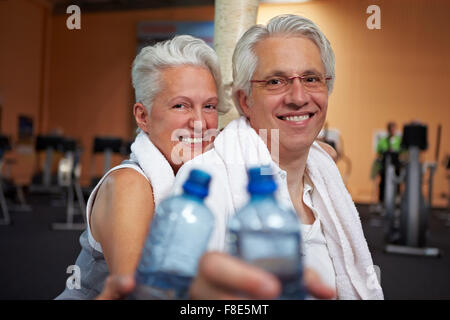 Two happy senior people in a gym drinking water Stock Photo
