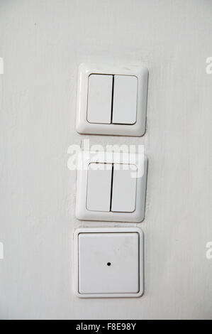 three Light switches on a wall Stock Photo