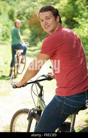 Yoing Couple Cycling In Countryside Stock Photo