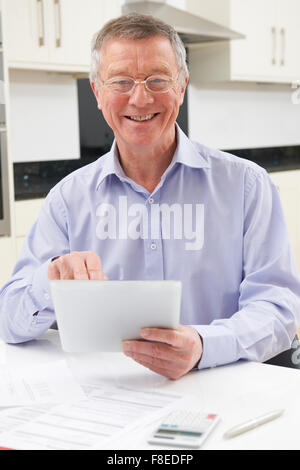 Senior Man Using Digital Tablet At Home Stock Photo
