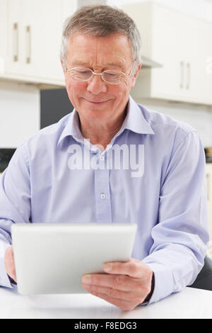 Senior Man Using Digital Tablet At Home Stock Photo