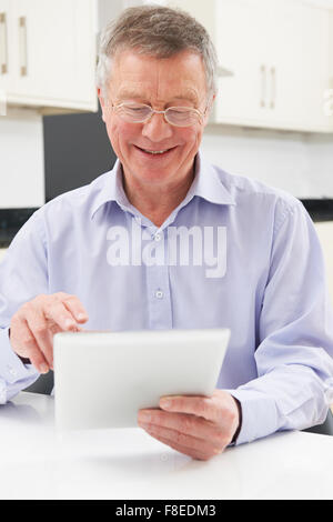 Senior Man Using Digital Tablet At Home Stock Photo