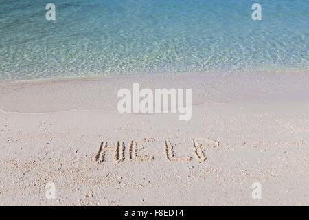 Help written out in wet sand on a tropical beach Stock Photo